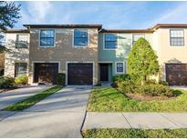 Charming townhomes with attached garages, landscaped front yards, and walkways leading to the front doors at 2453 Edgewater Falls Dr, Brandon, FL 33511