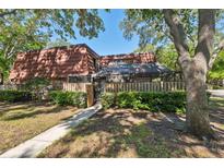 Charming condo with a brick exterior, red tile roof, and a lovely fenced front yard with mature landscaping at 2722 11Th Ct # 50A, Palm Harbor, FL 34684