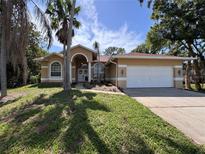 Charming single-story home featuring a well-manicured lawn, arched entryway, and attached two-car garage at 2752 Cypress Dr, Clearwater, FL 33763
