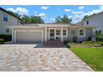 Charming single-story home featuring a brick driveway and well-manicured lawn with a welcoming front porch at 3906 W De Leon St, Tampa, FL 33609