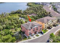 An aerial view shows a townhome near a beautiful lake surrounded by trees at 4624 Willet Cooper Ct, Tampa, FL 33619
