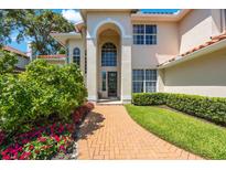 Inviting home featuring manicured landscaping and a brick path leading to the arched front entrance at 4815 Queen Palm Ne Ter, St Petersburg, FL 33703