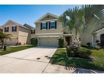 Charming two-story home with a well-maintained lawn, a palm tree and neutral color scheme at 5928 81St N Ave, Pinellas Park, FL 33781