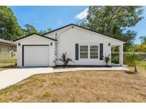 Charming single-story home featuring a well-manicured lawn, a garage, and freshly painted exterior at 6204 Nebraska Ave, New Port Richey, FL 34653