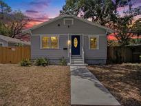 Charming single-story home features a welcoming blue door and well-maintained landscaping at 8114 N 11Th St, Tampa, FL 33604