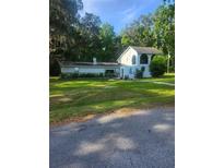 Charming home featuring stone accents, stucco exterior, and lush landscaping, set against a backdrop of mature trees at 9481 Patrick St, Brooksville, FL 34601