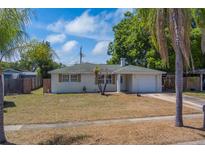 Charming single-story home with a well-maintained front yard and attached garage on a sunny day at 11546 Leisure W Ln, Largo, FL 33773