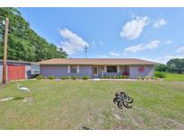 Charming single-story home featuring a well-maintained lawn and inviting curb appeal at 13208 Sydney Rd, Dover, FL 33527