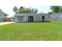 Charming home featuring a manicured green lawn, double door entrance and a light gray exterior paint at 2288 Cheryl Rd, Largo, FL 33771