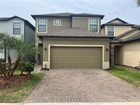 Two-story home featuring a brick driveway and a two-car garage with neutral paint and manicured landscaping at 2733 Hampton Green Ln, Brandon, FL 33511