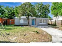 Charming single-story home with gray exterior, blue door, and well-manicured front yard at 3003 E 27Th Ave, Tampa, FL 33605