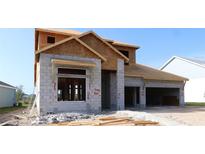 A new construction home featuring concrete block and wood framing, set against a clear blue sky in a residential neighborhood at 31418 Hayman Loop, Wesley Chapel, FL 33545