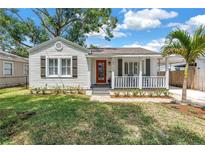 Charming single-story home featuring a red front door, white picket fence, and a well-manicured lawn at 3709 W Santiago St, Tampa, FL 33629