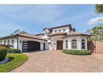 Stunning two-story home with a terracotta tile roof, brick driveway, and beautiful landscaping at 3931 Pompano Se Dr, St Petersburg, FL 33705