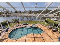 Screened-in pool with a water view, attached jacuzzi, and outdoor seating at 3931 Pompano Se Dr, St Petersburg, FL 33705
