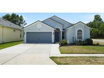 Charming single-story home with a well-manicured lawn and attached two-car garage, painted in light blue at 4105 Waterville Ave, Wesley Chapel, FL 33543