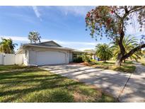 Charming single-story home featuring a well-manicured lawn, two-car garage, and beautiful mature trees in a sunny setting at 5810 Venetian Ne Blvd, St Petersburg, FL 33703