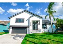 Charming two-story home with a manicured lawn and modern architectural details, showcasing curb appeal at 6509 Dolphin Cove Dr, Apollo Beach, FL 33572