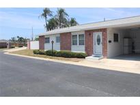 Attractive home featuring brick accents, a covered entry, manicured landscaping, and a carport at 12400 Park Blvd # 111, Seminole, FL 33772
