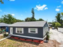 Charming single-story home featuring a new roof, blue siding, white trim, and fresh landscaping at 1402 Freemont S St, Gulfport, FL 33707