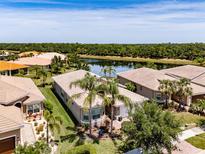 Beautiful single-story home with lush landscaping and tile roof overlooking a serene lake at 16106 Cedar Key Dr, Wimauma, FL 33598