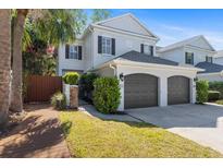 Two-story townhome featuring a two-car garage and manicured landscaping at 202 S Lincoln Ave, Tampa, FL 33609