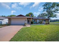 Charming single-story home featuring a two-car garage and a well-maintained front yard at 2967 Macalpin N Dr, Palm Harbor, FL 34684