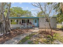 Charming single-story home featuring a blue door and trim, complemented by lovely landscaping and a stone walkway at 3025 50Th St S S St, Gulfport, FL 33707