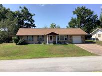 Charming single-story home with stone accents, attached garage, manicured lawn, and inviting curb appeal at 31258 Park Ridge Dr, Brooksville, FL 34602