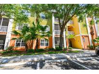 View of a charming multi-story building with tropical landscaping, colorful facade, and screened-in balconies at 4207 S Dale Mabry Hwy # 12206, Tampa, FL 33611