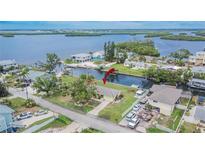 Aerial view of waterfront home with dock, lush landscaping, and stunning bay views at 814 Seabreeze Dr, Ruskin, FL 33570
