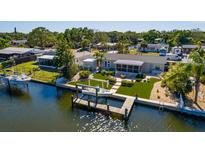 Waterfront home featuring a private dock and boat lift and manicured landscaping at 9301 Sun Isle Ne Dr, St Petersburg, FL 33702
