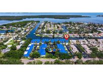 An overhead shot showcases the neighborhood and a building with a blue roof near the ocean at 1625 Watermark Ne Cir, St Petersburg, FL 33702