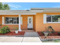 Charming front entryway of home with white trim, an oval-window door, and plants at 3065 Merrill Ave, Clearwater, FL 33759