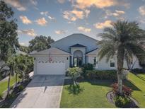Charming single-Gathering home featuring a well-manicured lawn, mature palms, and an attached two-car garage at 413 8Th N Ave, Tierra Verde, FL 33715