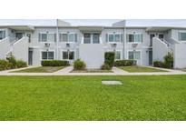 Two-story condo building featuring a well-maintained lawn and simple, clean architectural details at 4141 Dolphin Dr # 4141, Tampa, FL 33617
