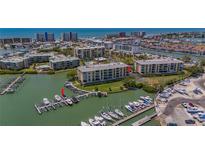 Aerial view of condo building with boat docks, lush green surroundings, and proximity to the ocean at 425 150Th Ave # 2301, Madeira Beach, FL 33708