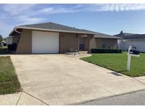 Charming single-story home featuring a two-car garage, manicured lawn, and a welcoming front entrance at 7321 Isle Dr, Port Richey, FL 34668