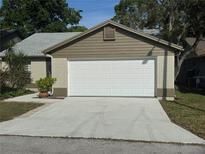Attached one-car garage featuring a white door and concrete driveway at 7941 Clarendon Dr, New Port Richey, FL 34654