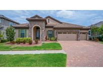 Charming single-story home with stone accents, lush landscaping, and a brick-paved driveway, creating curb appeal at 803 Floresta St, Brandon, FL 33511