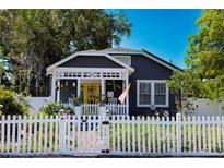 Charming home with a bright yellow door and a white picket fence creating a welcoming curb appeal at 1036 23Rd N Ave, St Petersburg, FL 33704