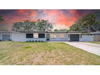 Charming single-story home featuring fresh white paint, black accents and an attached garage at 1416 Murray Ave, Clearwater, FL 33755