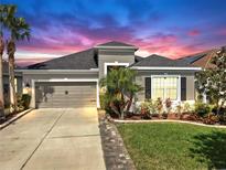Charming single-Gathering home showcasing a well-manicured lawn and lovely landscaping at sunset at 17529 Buckingham Garden Dr, Lithia, FL 33547