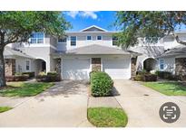 Charming townhome with two-car garage, stone accents, and well-maintained landscaping at 19281 Stone Hedge Dr, Tampa, FL 33647