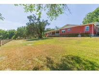 Sprawling brick ranch-style home with large yard and mature trees creates a peaceful and private setting at 34211 Blanton Rd, Dade City, FL 33523