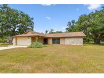 Ranch-style home with stone accents, attached garage, and well-maintained front lawn at 5306 Downing St, Dover, FL 33527