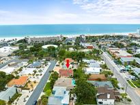 Amazing aerial view of cozy home near the sandy beach with clear water and lush greenery, perfect for relaxation at 75 Lido Dr, St Pete Beach, FL 33706