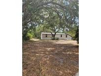 Charming single-story home with neutral siding and mature trees offering shade and curb appeal at 8255 Richmond St, Gibsonton, FL 33534