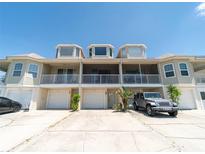 Three-story exterior showcasing garages, balconies, and well-maintained facade of the townhome at 8304 Aquila St, Port Richey, FL 34668