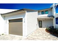 Charming home features a two-car garage, stone walkway, and neutral paint scheme at 8753 Bay Pointe Dr, Tampa, FL 33615